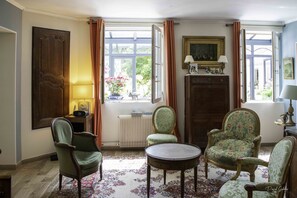 A room with a large window, a radiator, a table, and two chairs. - Villa marguerite charming bed and breakfast (Ponts-et-Marais)