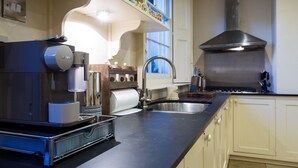 Una cocina equipada con cafetera, lavaplatos y estufa.