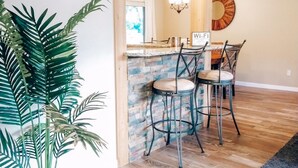 Een moderne keuken met houten balken, een steenschild en een bar.