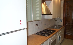 Fully equipped kitchen with refrigerator, stove, oven, and sink.