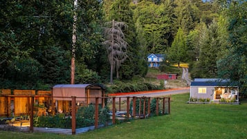 Un rustico chalet con una terrazza in legno, immerso in una fitta foresta.