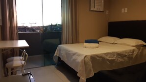 A hotel room with a bed, a desk, and a chair. - Pousada São Pedro (Sao Pedro da Aldeia)