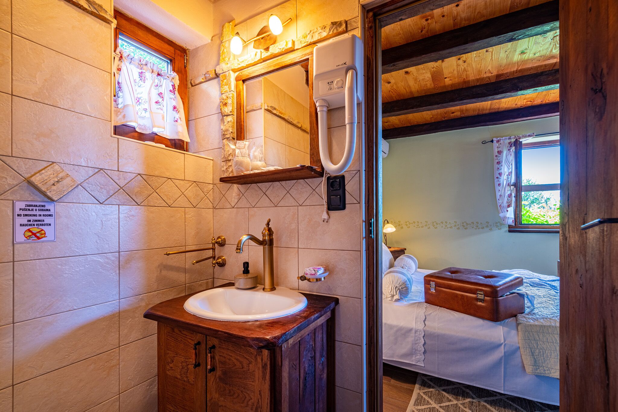Un baño con lavamanos, espejo y ducha.