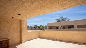 Un'ampia stanza luminosa, con soffitto alto e vista sui palazzi vicini.