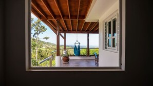 Ein Zimmer mit Blick auf einen Hängestuhl und einen Blumentopf auf dem Balkon.