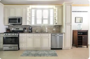 Enjoy cooking in this well-equipped kitchen with a coffee maker, stainless steel appliances, and a large window.