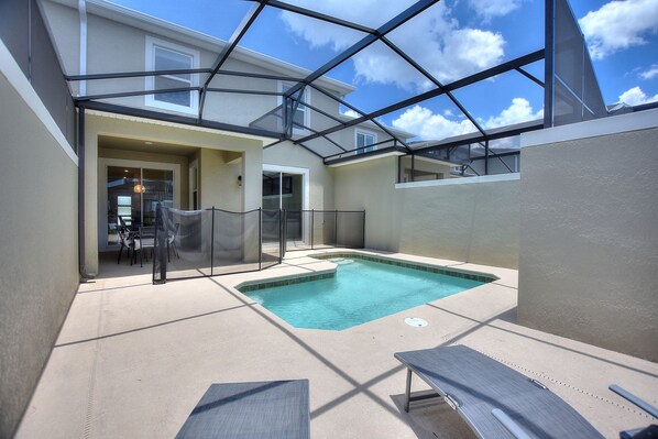 Une piscine intérieure avec des murs en verre, des chaises longues et une vue sur le ciel.