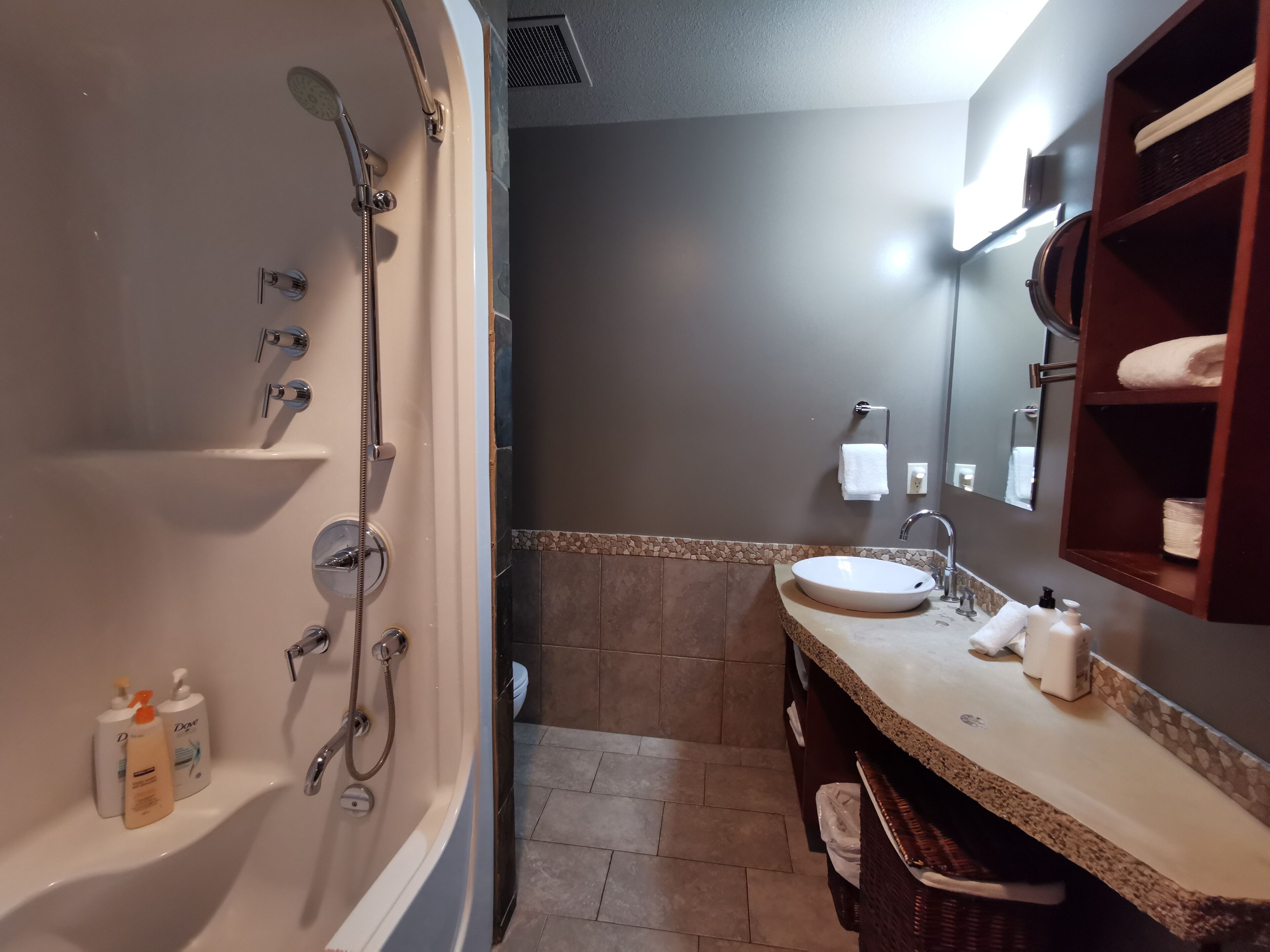 A modern bathroom with a bathtub, shower, and sink.