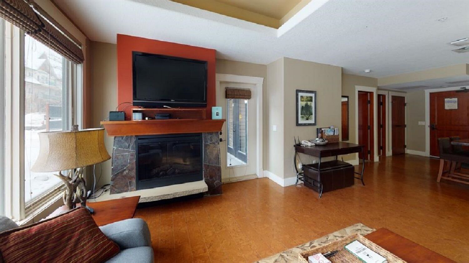 A living room with a fireplace, a television, and a dining area.