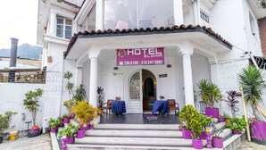 A hotel entrance with a sign reading "HOTEL ELOINA," contact numbers, and a staircase leading to the entrance. - Ayenda Eloina (Bogotá)