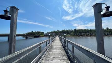 A wooden pier extending into a body of water with a clear sky above.