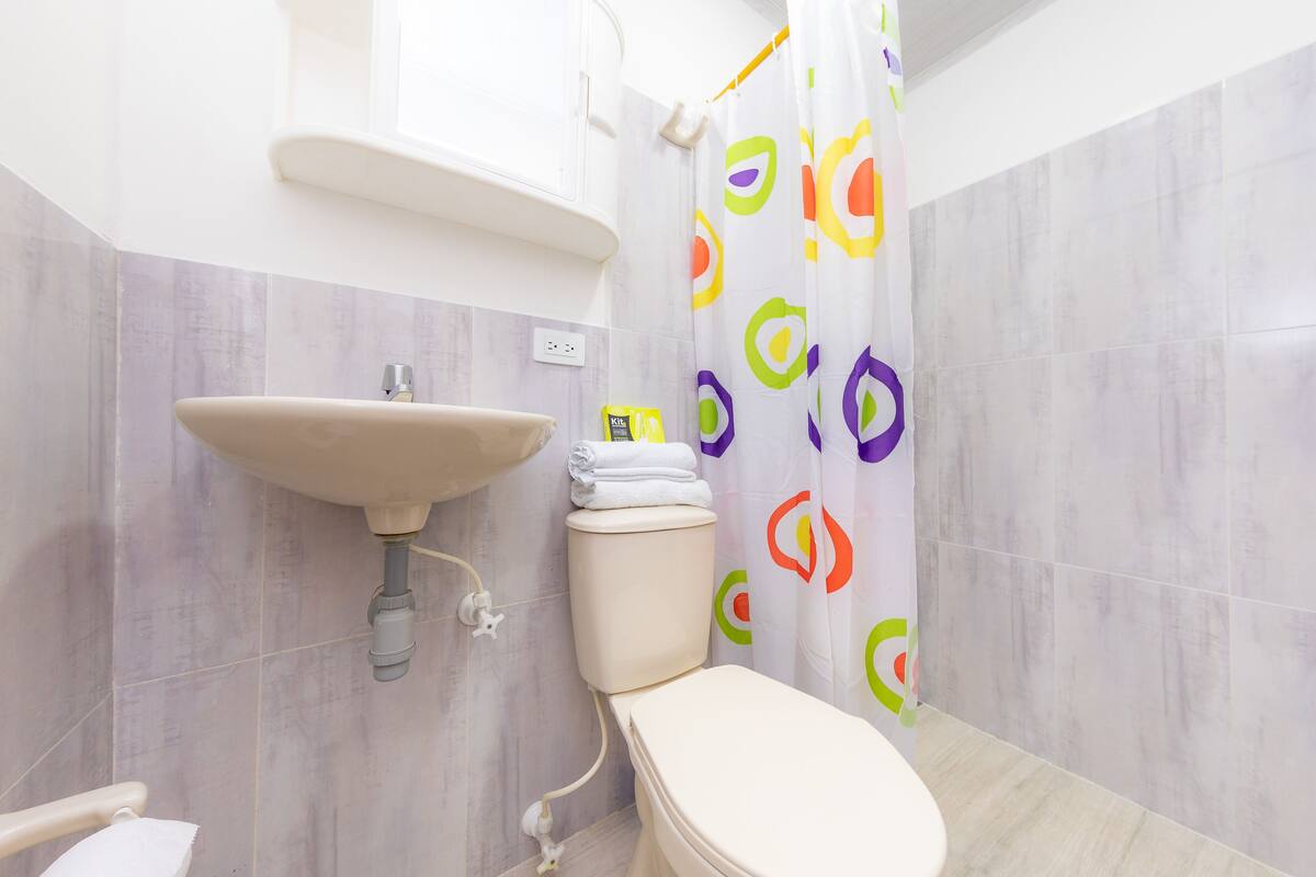 A bathroom with a sink, toilet, and shower curtain.