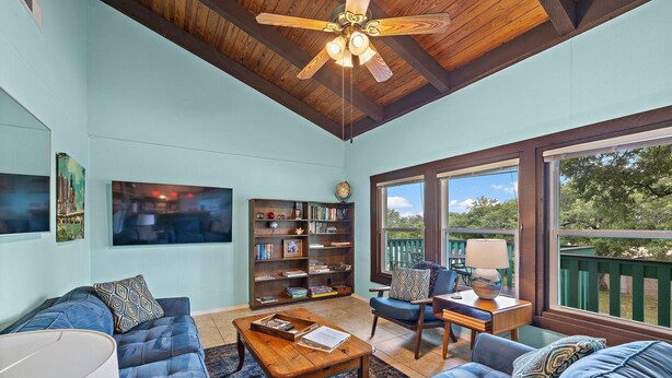 A cozy living room with a blue sofa, a wooden coffee table, and a bookshelf.