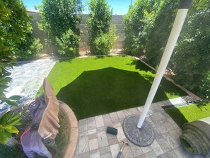 A well-maintained garden with a lawn, a pergola, and a brick pathway.