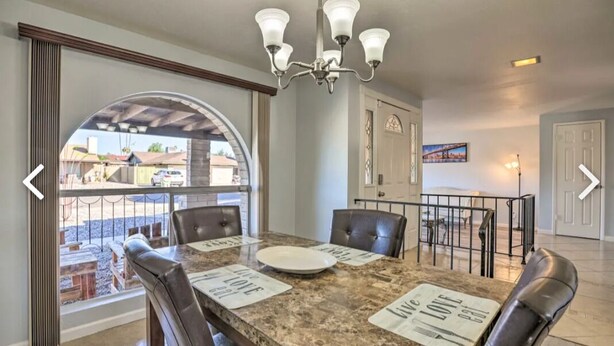 A dining area with a marble table, leather chairs, and a chandelier. - Beautiful 4 bedroom 2 bathroom with pool and pool table for your entertainment (Glendale)