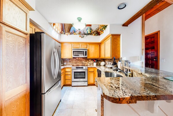 Enjoy cooking in this well-equipped kitchen with a refrigerator, oven, and microwave.