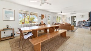 Un salón amplio con una mesa de comedor de madera, un sofá y una chimenea.