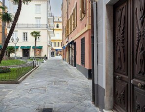 Stroll along the charming pathway lined with a garden and traditional buildings.