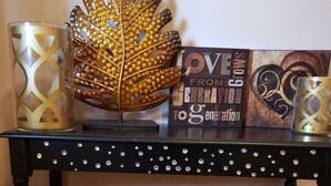 A black table with decorative elements and a sign that reads "LOVE FROM GENERATION TO GENERATION". - 2 bedroom holiday home (Tropic)