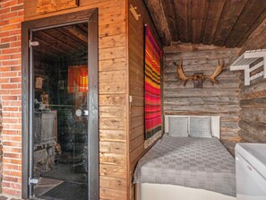 A log cabin with a bed, a fireplace, and a deer head mounted on the wall. - Urpola riviera by Interhome (Rovaniemi)