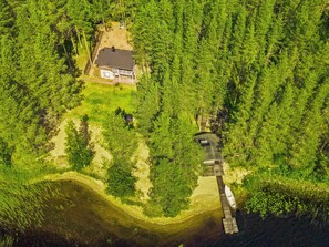 An aerial view of a house surrounded by dense forest, with a dock extending into a body of water. - Urpola riviera by Interhome (Rovaniemi)