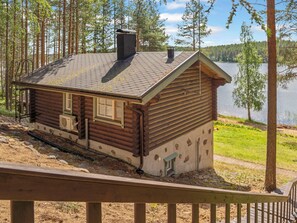 A log cabin with a chimney, windows, and a small porch. - Urpola riviera by Interhome (Rovaniemi)