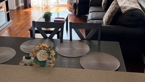 Una sala moderna con sofá, mesa de centro y objetos decorativos. Unos ventanales corredizos dan a un patio exterior.