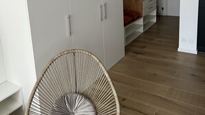 A room with a hanging chair, white wardrobes, and a wooden floor. - A 20 Mètres des Remparts Appartement Avec Parking (Avignon)
