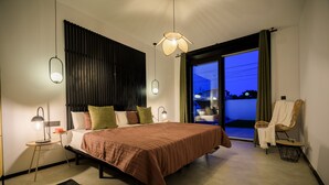 Une chambre moderne avec un grand lit, des lampes de chevet, un tapis tissé et une vue sur l’extérieur grâce à une porte coulissante.