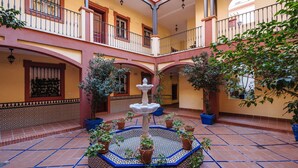A courtyard with a central fountain, potted plants, and tiled flooring. - Beautiful & Bright Apartment for 4 People, Parking Optional (Sevilla)