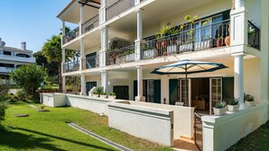 A multi-story building with balconies, potted plants, and a well-maintained lawn. - Outstanding one bedroom apart with heated private pool in Vale do Lobo (Almancil)