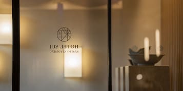 Une enseigne d’hôtel avec un logo géométrique et le nom « HÔTEL SULTAN ».