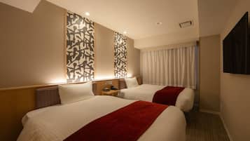 Une chambre d’hôtel avec deux lits, un téléviseur fixé au mur et une fenêtre avec des rideaux.