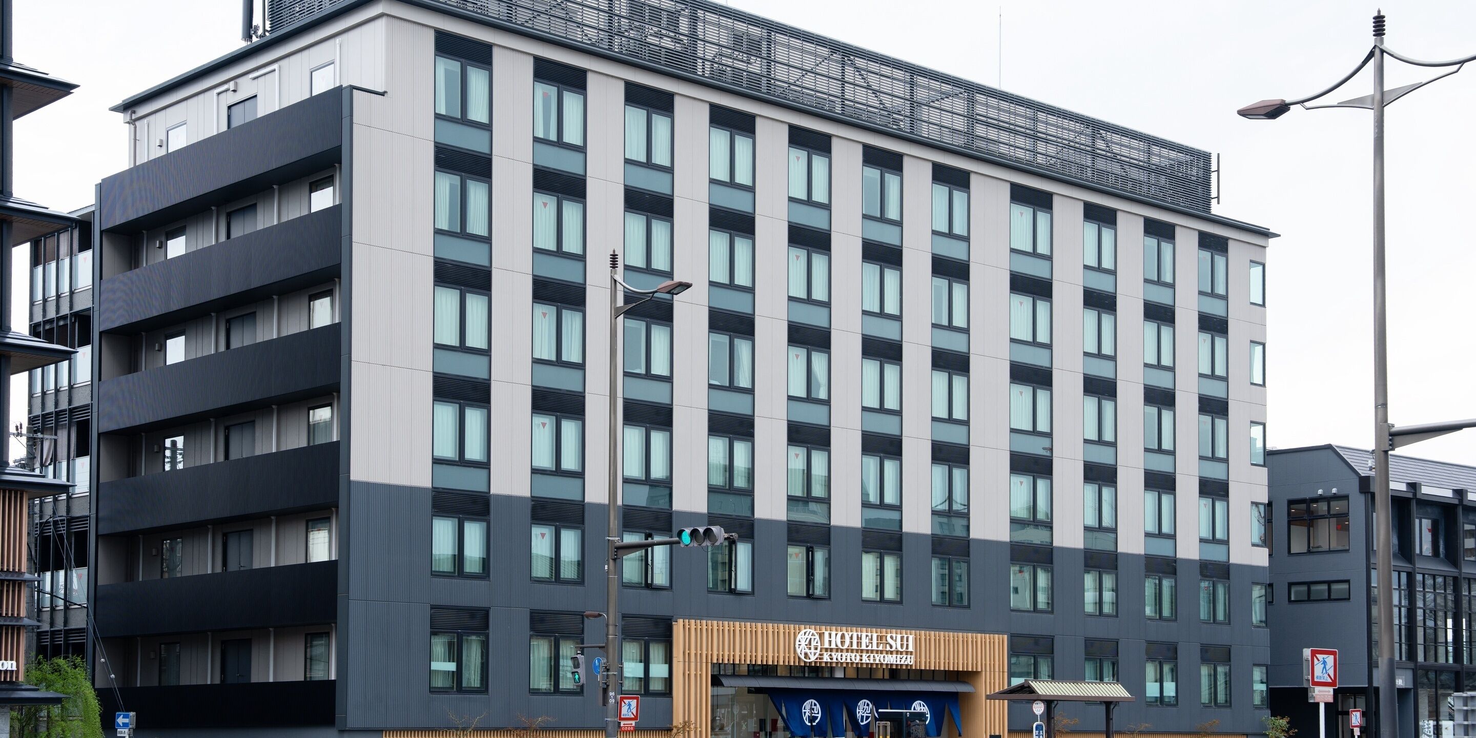 A multi-story hotel with a modern facade, large windows, and a sign indicating it is a hotel.