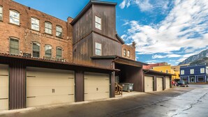 A row of industrial-style buildings with large garage doors, a metal staircase, and a clear blue sky. - Contemporary Cozy Loft | Heart of Downtown | Air Conditioning (Ouray)