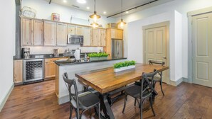 A modern kitchen with wooden cabinets, stainless steel appliances, and a central island with chairs. - Contemporary Cozy Loft | Heart of Downtown | Air Conditioning (Ouray)