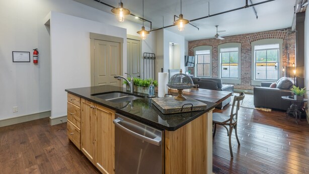 A modern kitchen with a large island, wooden cabinets, and stainless steel appliances. - Contemporary Cozy Loft | Heart of Downtown | Air Conditioning (Ouray)