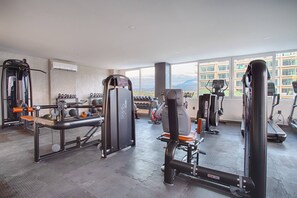 A gym with various exercise equipment, including weight machines, a treadmill, and free weights. - Family-Friendly 1BR + Flex | Pool, Gym, Parking (Puerto Vallarta)