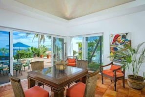 A spacious patio with a glass table and wicker chairs, overlooking a tropical garden and palm trees. - 5BR Palmilla Villa - Great for families! (Palmilla Norte)