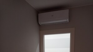 A room with a door leading to a balcony, an air conditioning unit above the door, and a power outlet on the wall. - Regis Apartament (Milazzo)
