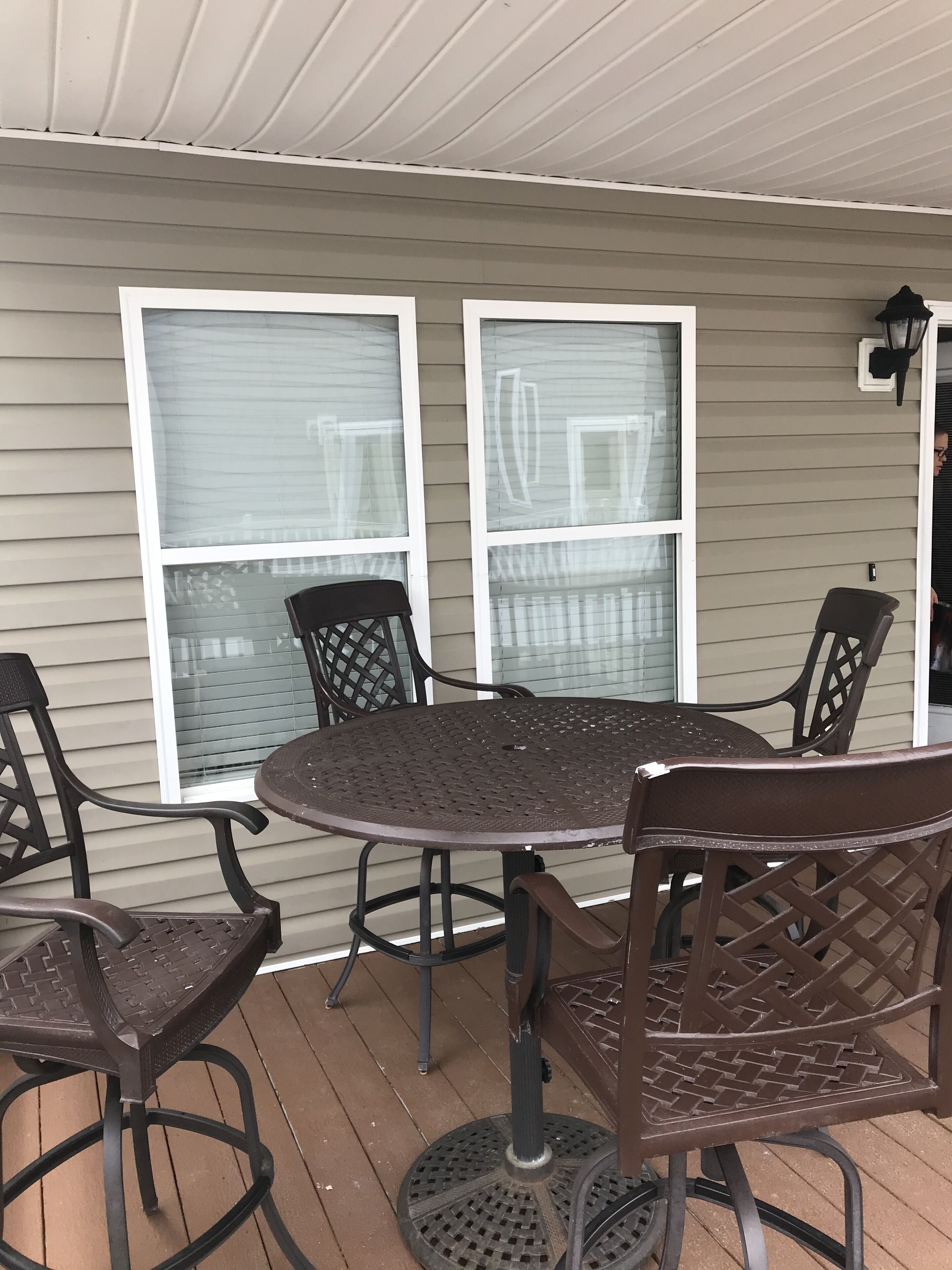 Ein überdachter Patio-Bereich mit einem runden Tisch und sechs Stühlen.