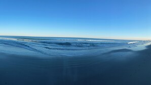 A beach with waves and a clear sky. - Book now for the SUMMER before it’s gone @ Ocean Lakes Family Campground!! (Myrtle Beach)