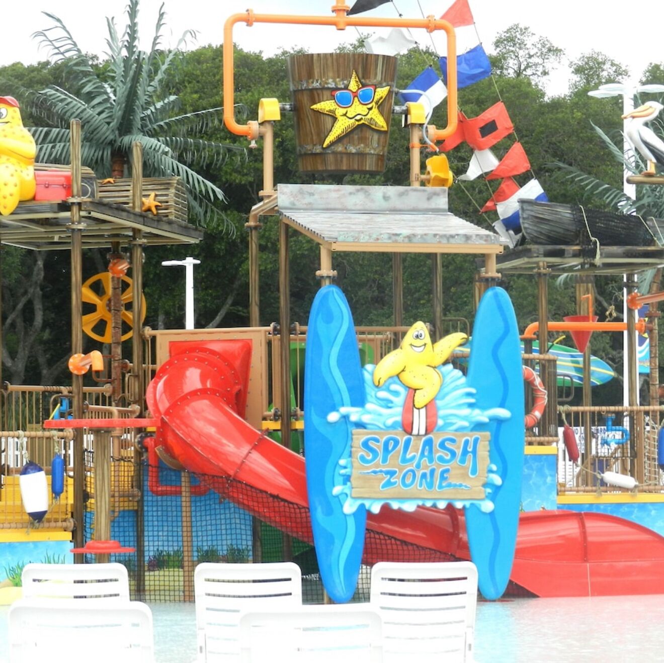 Ein Wasserpark mit einem Schild 'Splash Zone', Rutschen und einer Holzkonstruktion mit einer Sterndekoration.