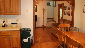 A kitchen with wooden cabinets, a refrigerator, and a dining table with chairs. - Cozy Home Away from Home. Sleeps 12! (Sugar Mountain)