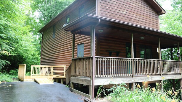 A wooden cabin with a porch and a small ramp leading to the entrance. - Cozy Home Away from Home. Sleeps 12! (Sugar Mountain)