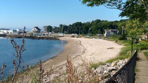 A beach with a sandy shore, a rocky breakwater, and a clear blue sky. - Crescent Beach Cottage - Vacation or Academic Rental (Niantic)