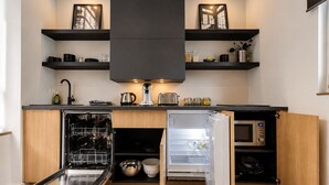 Une cuisine moderne dotée d’appareils électroménagers intégrés, de meubles de rangement en bois et d’un lave-vaisselle.