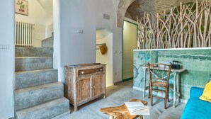 A staircase leading to a room with a rustic wooden cabinet, a table with chairs, and a blue sofa. - Sunsets over Ostuni and the sea - OSTUNI STYLE (Ostuni)