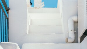 A white staircase leading to a rooftop area with a white building and a blue sky in the background. - Sunsets over Ostuni and the sea - OSTUNI STYLE (Ostuni)