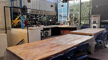 Un restaurant doté d’un long comptoir, de chaises bleues et d’un espace cuisine comprenant un réfrigérateur et un four à micro-ondes.